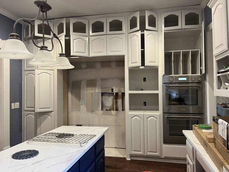 White painted cabinets with a navy blue island