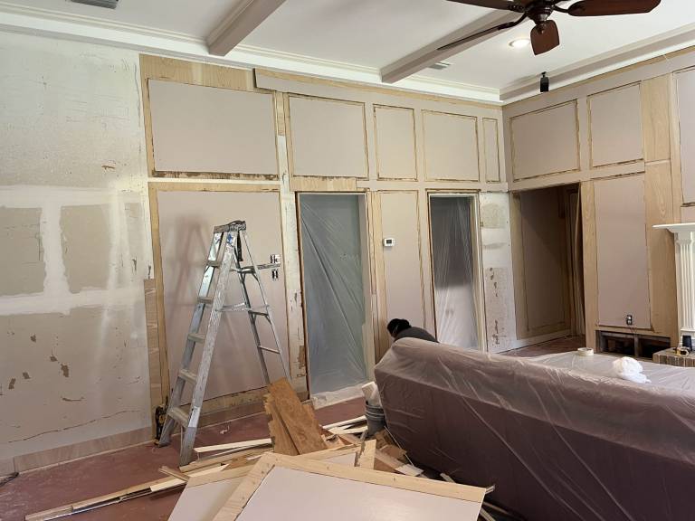 New drywall installed around the fireplace and built-ins