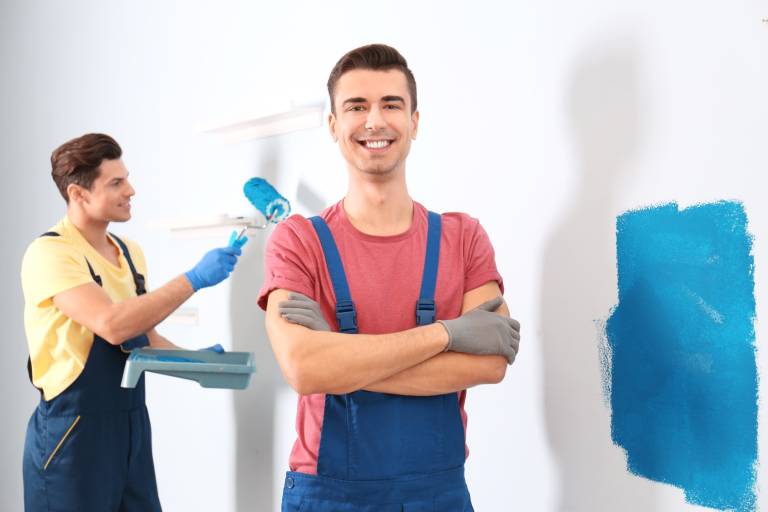 Professional painters painting a wall together